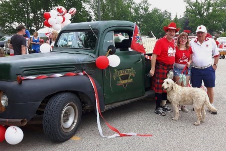 Family posing for picture in front of a truck