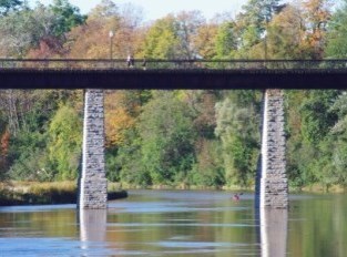 Span of trestle bridge over water during sunset