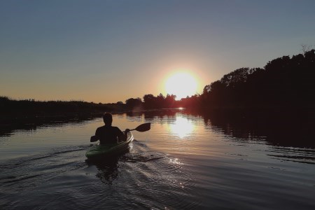 Man kayaking at sunset
