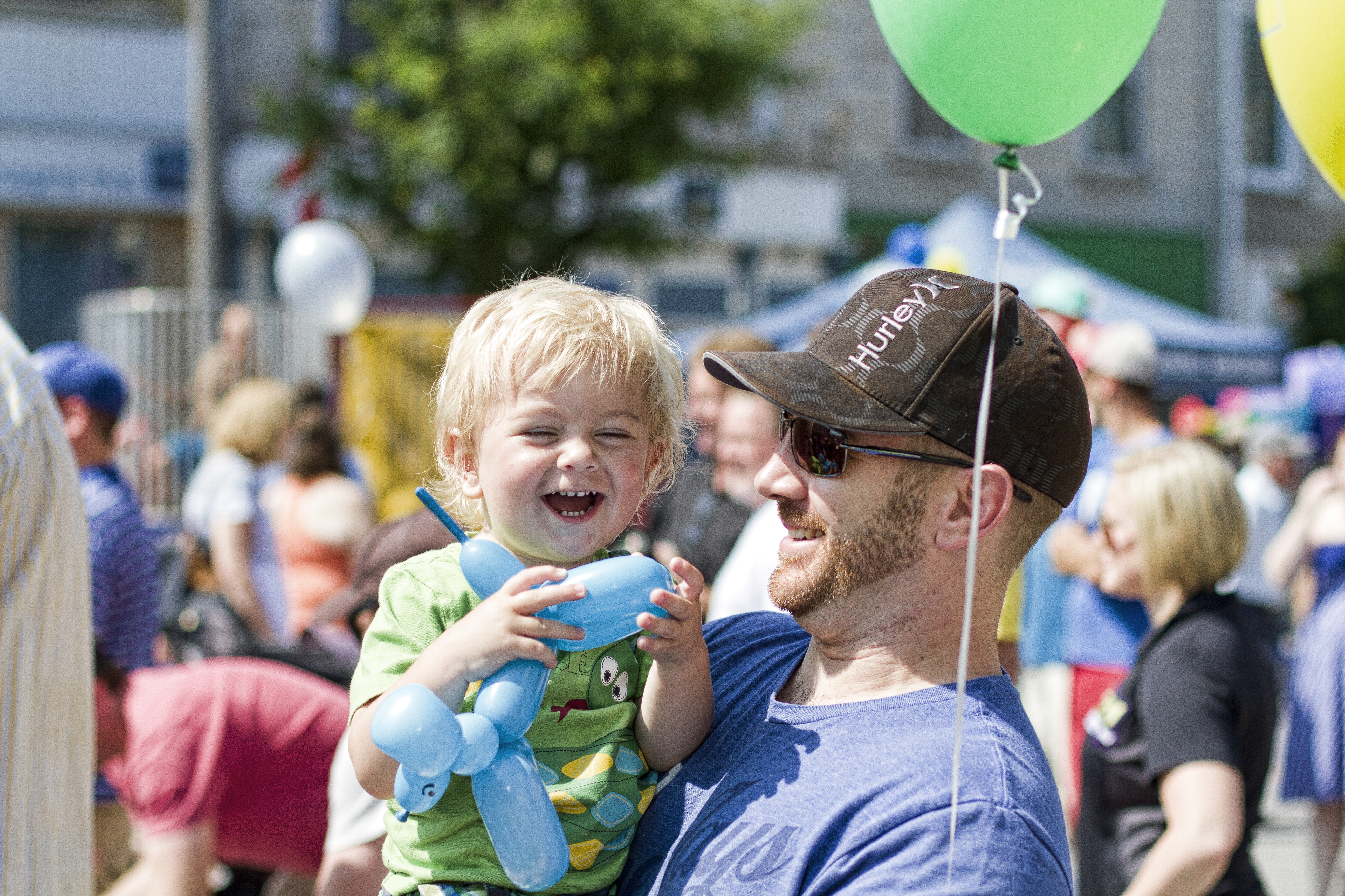 Person holding happy child at street festival