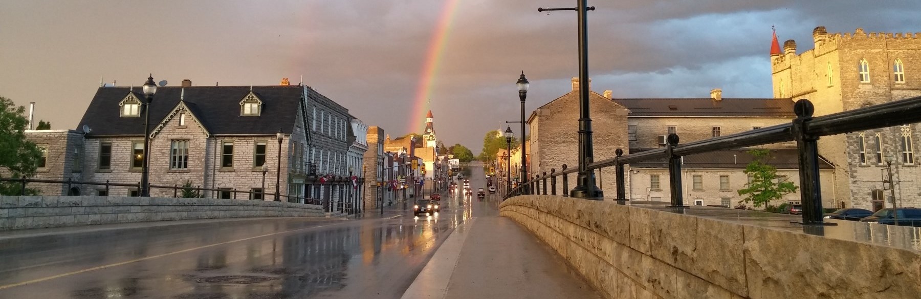 View of downtown streets on a rainy day with a rainbow in the background