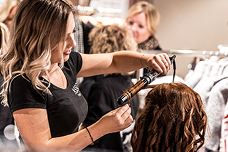 Hair stylist curling customers hair